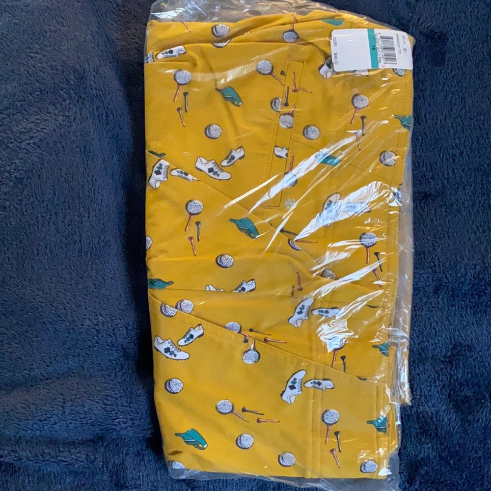 Izod men’s golf pants. Yellow with golf shoe, ball, and tee patterning.
